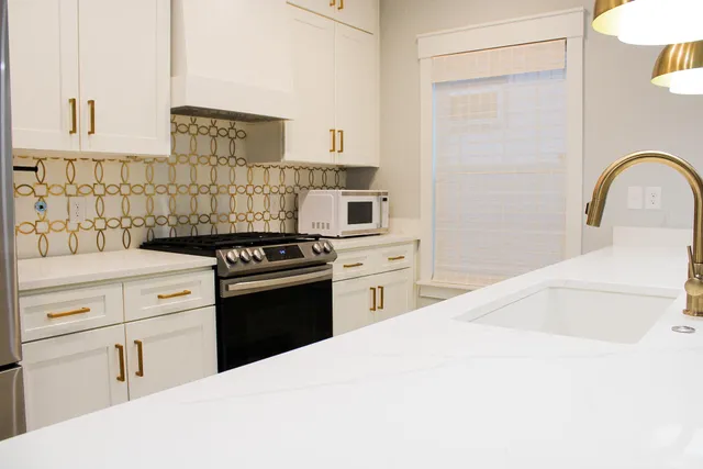 a kitchen with white cabinets and appliances