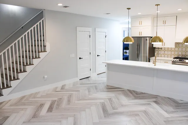 a view of a kitchen with kitchen island stainless steel appliances refrigerator stove microwave and cabinets