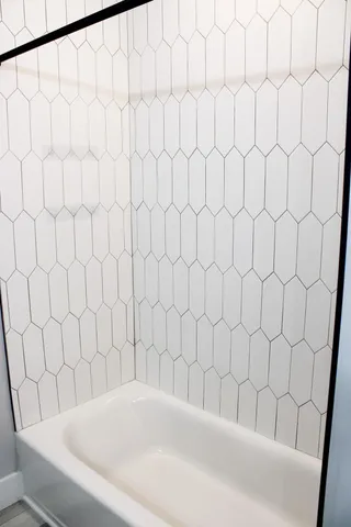 a bathroom with a white bathtub and curtain