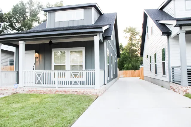 a view of a house with a small yard and wooden fence