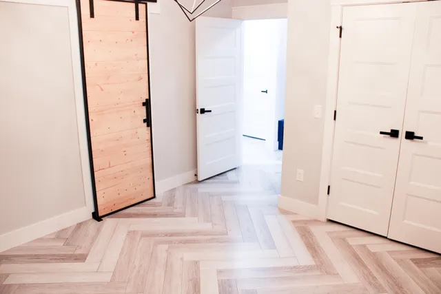 an entryway with wooden floor and cabinet