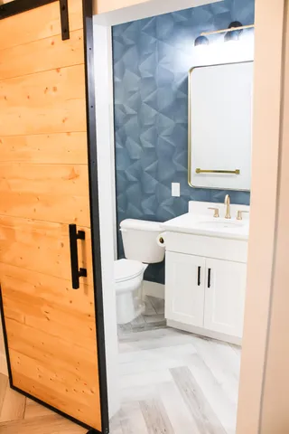 a bathroom with a sink a toilet and mirror