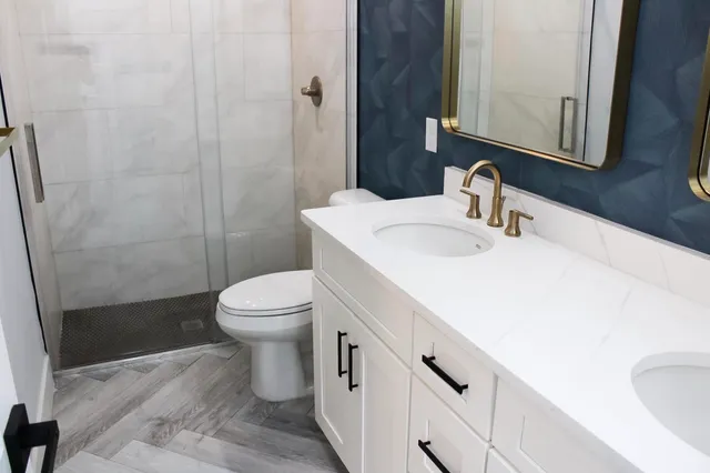 a bathroom with a sink a toilet and shower