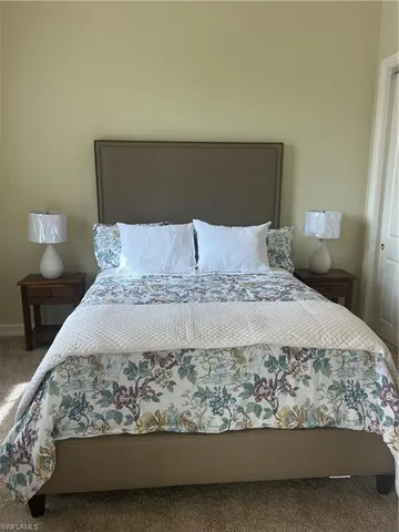 a large bed sitting in a bedroom next to a lamp