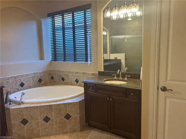 a bathroom with a tub sink and mirror