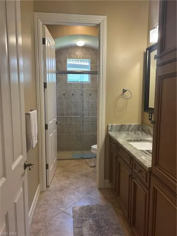 a bathroom with a granite countertop sink a toilet and shower