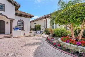 a front view of a house with a yard and a garden