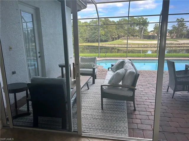 a view of a living room with a floor to ceiling window and wooden floor