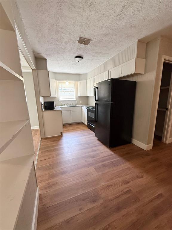 908 Sycamore Athens, TX 75751 - Photo 11 of 28 a view of kitchen with refrigerator stove and wooden floor