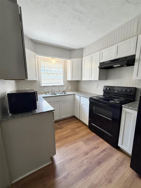 908 Sycamore Athens, TX 75751 - Photo 12 of 28 a kitchen with stainless steel appliances a sink a stove a microwave a refrigerator a window and cabinets