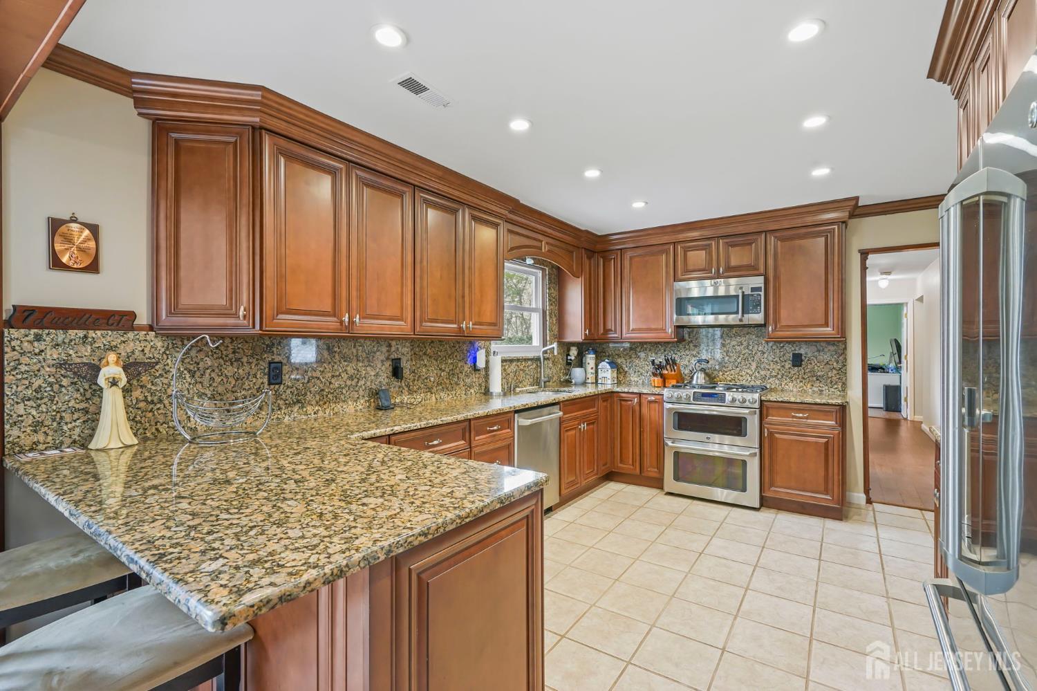 41 Rodak Circle Edison, NJ 08817 - Photo 12 of 28 a kitchen with stainless steel appliances granite countertop a refrigerator sink and cabinets
