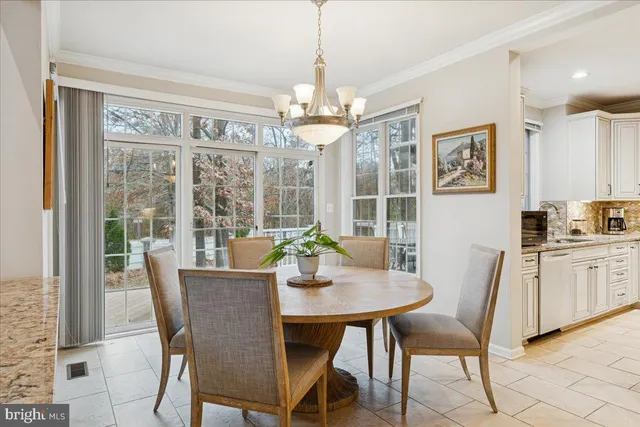 a dining room with furniture a chandelier and window
