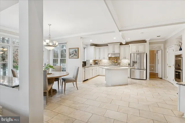 a kitchen with stainless steel appliances kitchen island granite countertop a refrigerator and cabinets