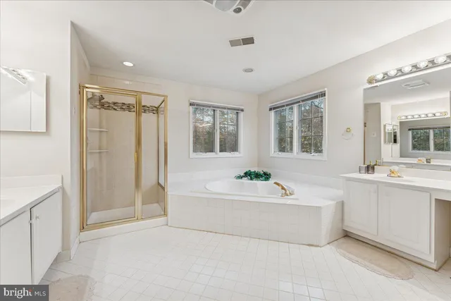 a spacious bathroom with a tub shower and sink
