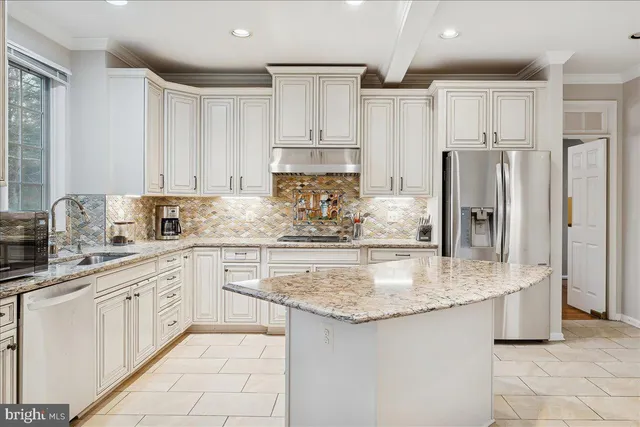 a kitchen with kitchen island granite countertop a sink stove and refrigerator