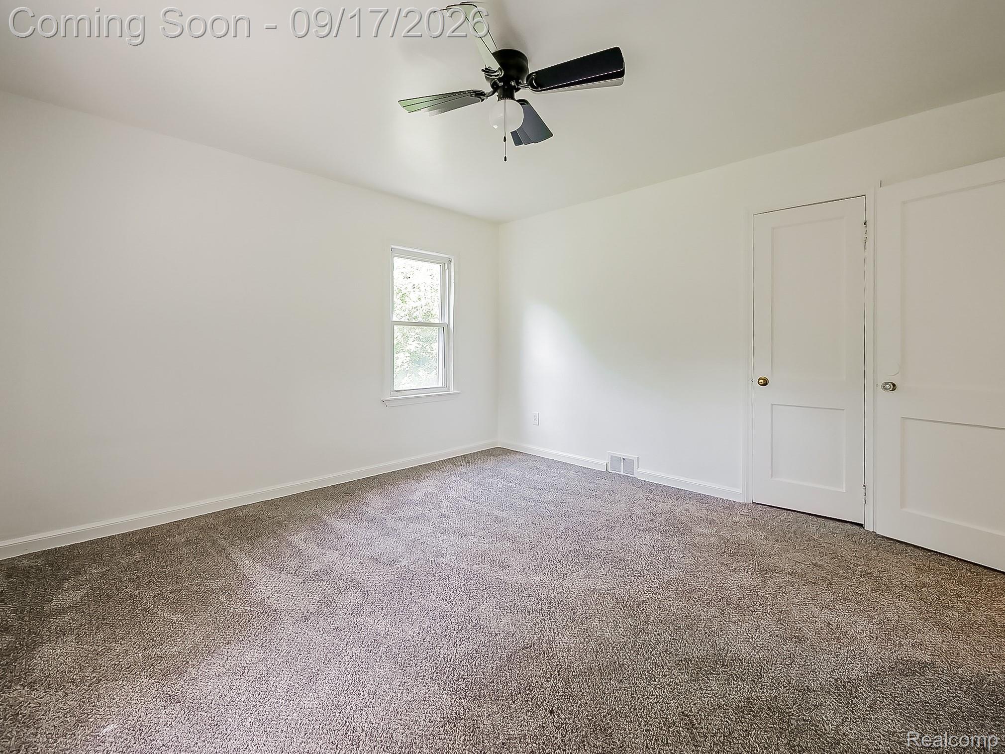 14102 Toepfer Road Warren, MI 48089 - Photo 9 of 39 Neutral wall paint, ceiling fan, carpeted flooring, and two white doors