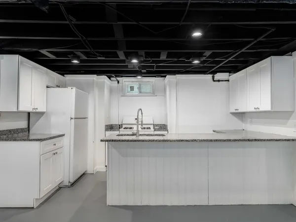 a kitchen with granite countertop a sink and cabinets