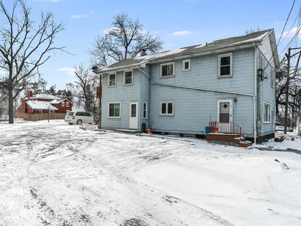 a front view of a house with a yard covered in snow