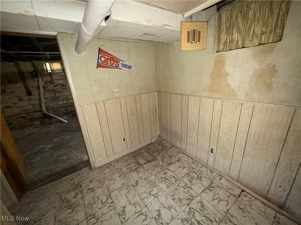 1979 Staunton Road Cleveland, OH 44118 - Photo 33 of 37 Unfinished below grade area with wooden walls, a wainscoted wall, and electric panel