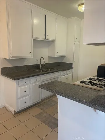 a kitchen with granite countertop a sink and a stove