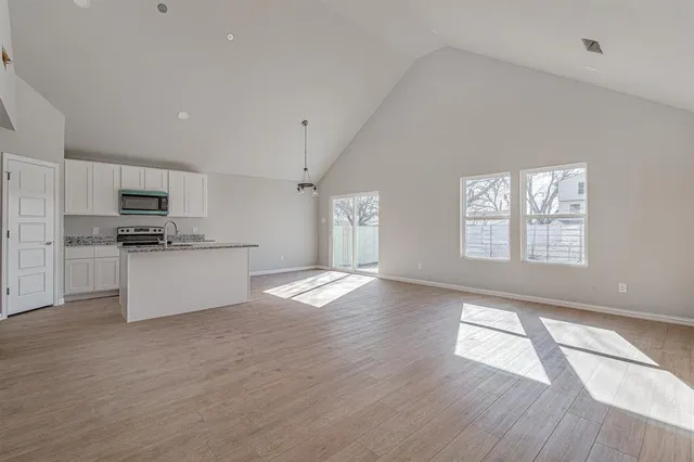 a kitchen with granite countertop white cabinets and stainless steel appliances