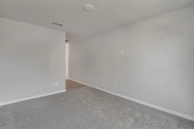 a bathroom with a granite countertop bathtub shower sink vanity mirror and toilet