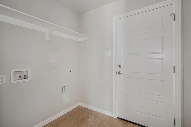 a large white kitchen with granite countertop a stove a sink a window and white wooden cabinets