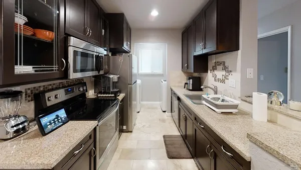 a kitchen with stainless steel appliances granite countertop a sink stove and refrigerator