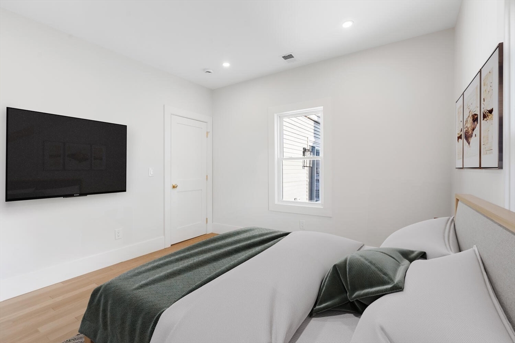 7 Bennett Street, Unit 1 Medford, MA 02155 - Photo 16 of 38 a bedroom with a bed and a flat screen tv