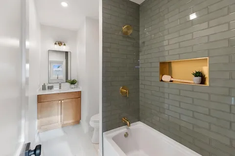 a bathroom with a tub a sink and mirror