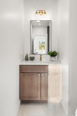a bathroom with a sink vanity and a mirror