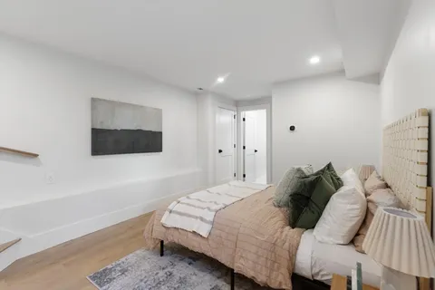 a bedroom with a bed and a painting on the wall