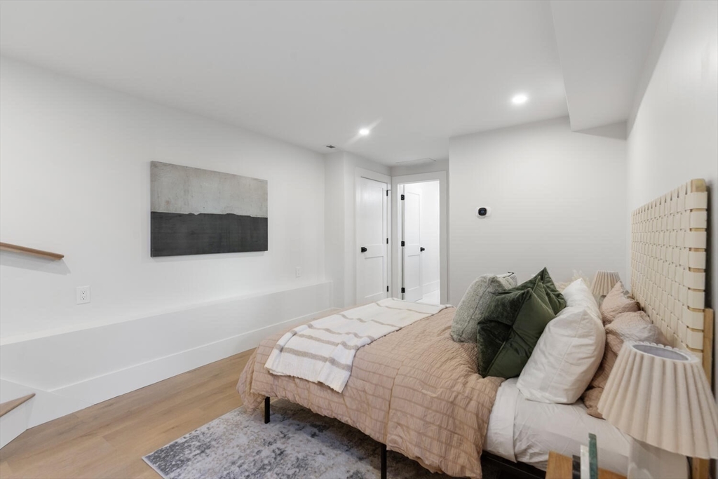 7 Bennett Street, Unit 1 Medford, MA 02155 - Photo 22 of 38 a bedroom with a bed and a painting on the wall