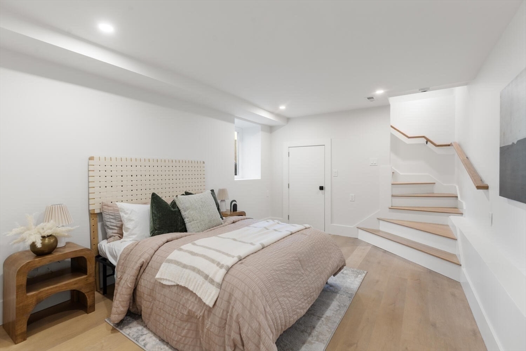 7 Bennett Street, Unit 1 Medford, MA 02155 - Photo 23 of 38 a bedroom with a bed and a lamp