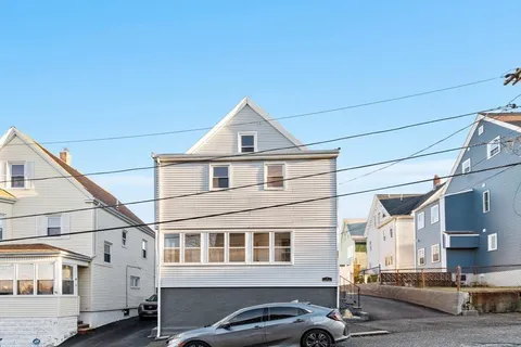 a front view of a house with a road