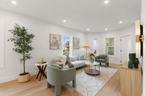 a living room with furniture potted plant and a table