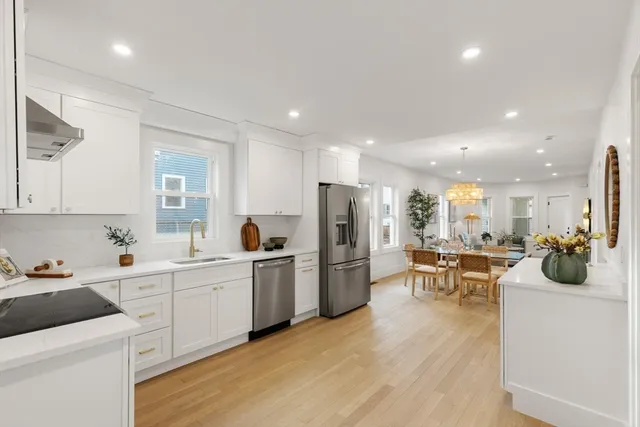 a kitchen that has a lot of cabinets a sink and appliances in it