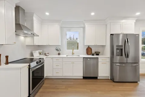 a kitchen with a white stove top oven and refrigerator