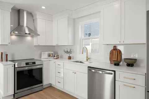 a kitchen with stainless steel appliances granite countertop a sink and a stove