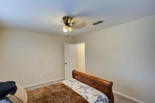 a bedroom with a bed and a chandelier fan