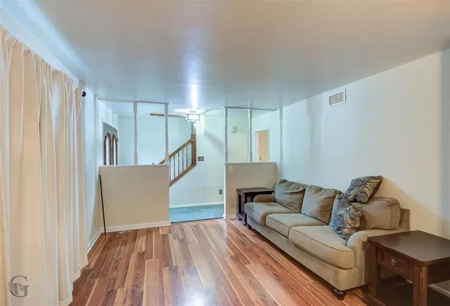 a living room with furniture and a wooden floor