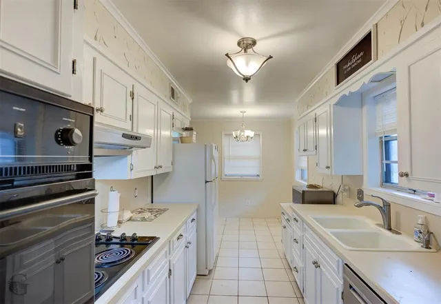 a kitchen with a sink appliances and cabinets
