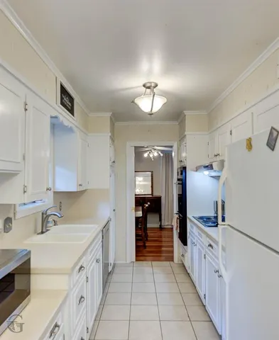a kitchen with granite countertop a refrigerator and a sink