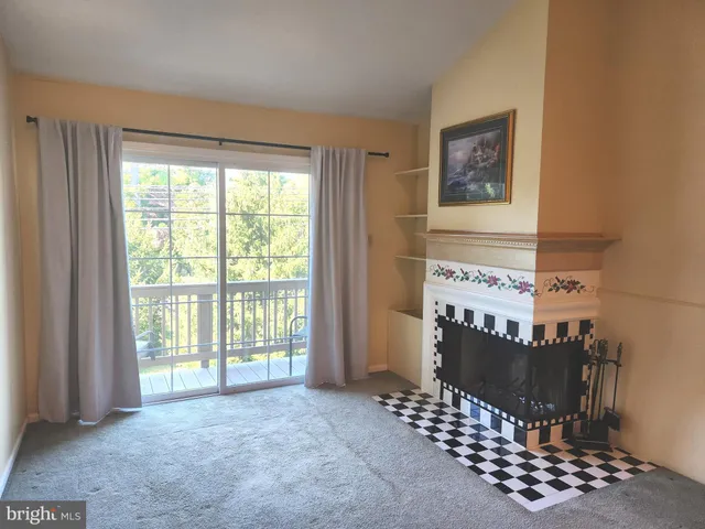 a view of a bedroom with wooden floor & a window
