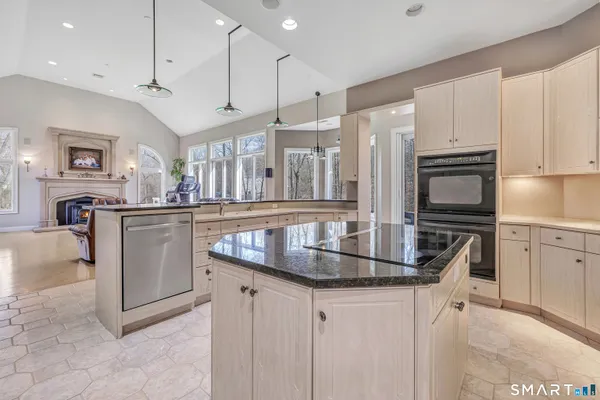 a kitchen with stainless steel appliances granite countertop a sink a stove and a refrigerator