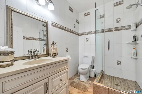 a bath room with a toilet a sink and a mirror