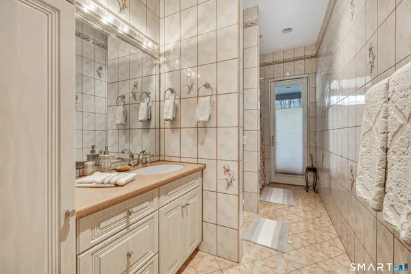 a bathroom with a sink shower and a mirror
