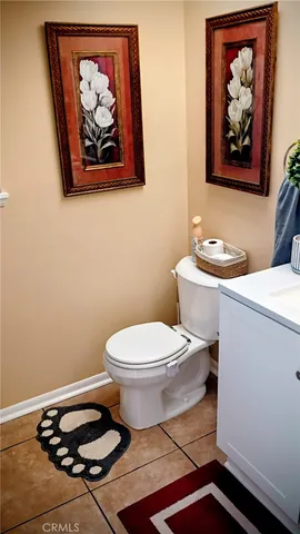 a bathroom with a toilet and a picture on the wall