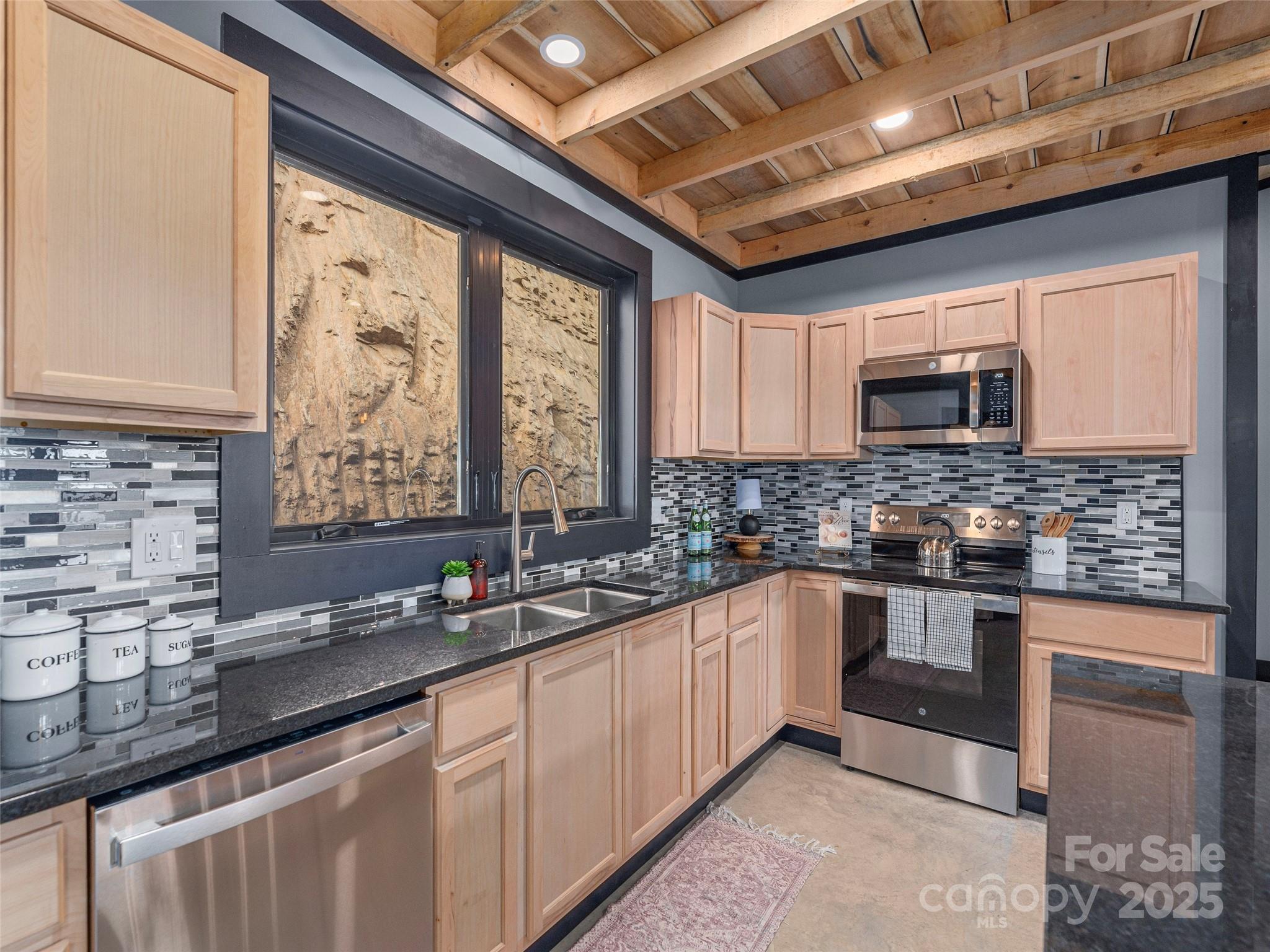 55 Dean Riddle Drive Waynesville, NC 28785 - Photo 14 of 35 a kitchen with stainless steel appliances granite countertop a sink a stove a microwave and cabinets
