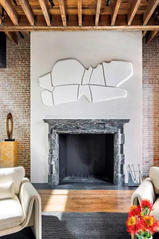 a living room with furniture a fireplace and floor to ceiling windows
